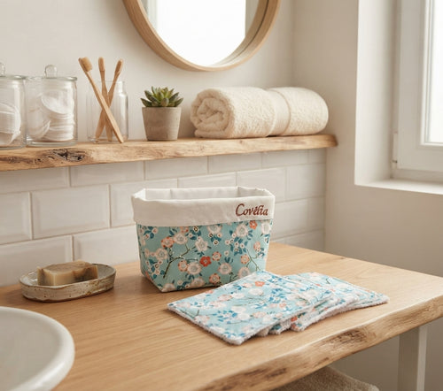 Lingettes démaquillantes lavables à motif fleuri bleu avec leur panière Covélia sur un meuble en bois 